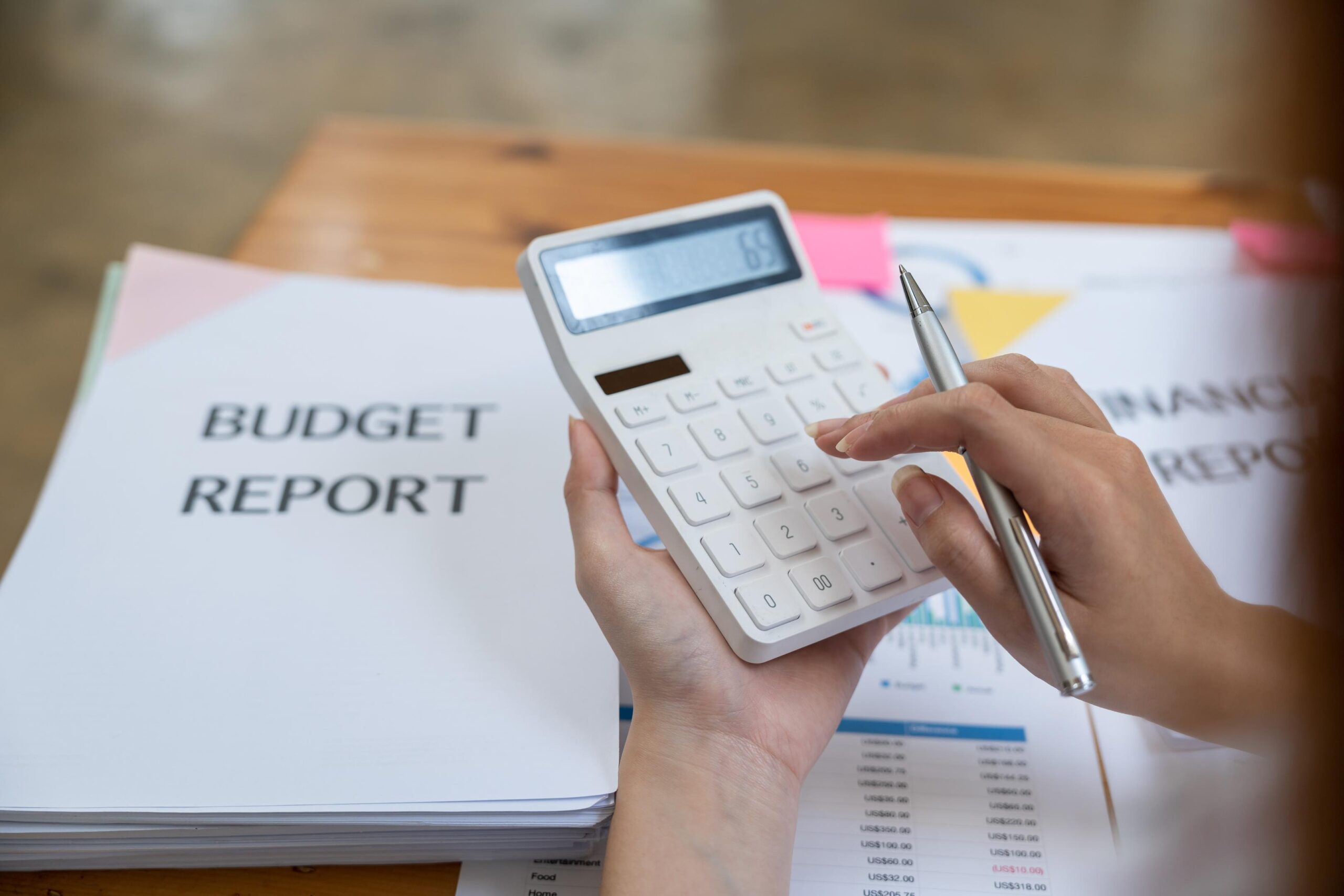 Top view of bookkeeper using calculator finance analyst looking and financial reports