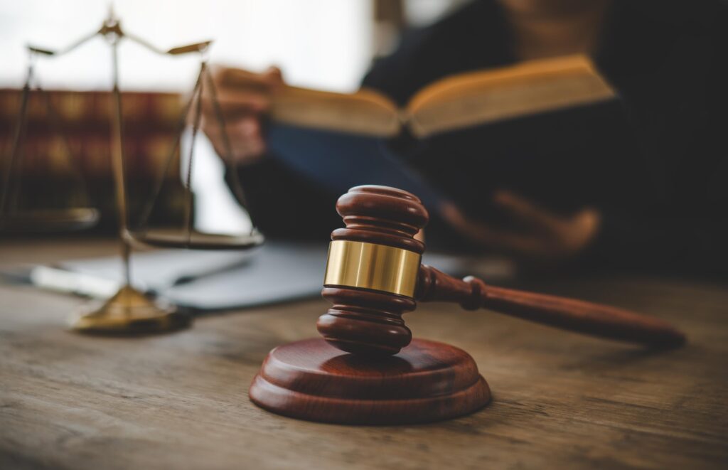 Scales of Justice and Gavel on Wooden Table